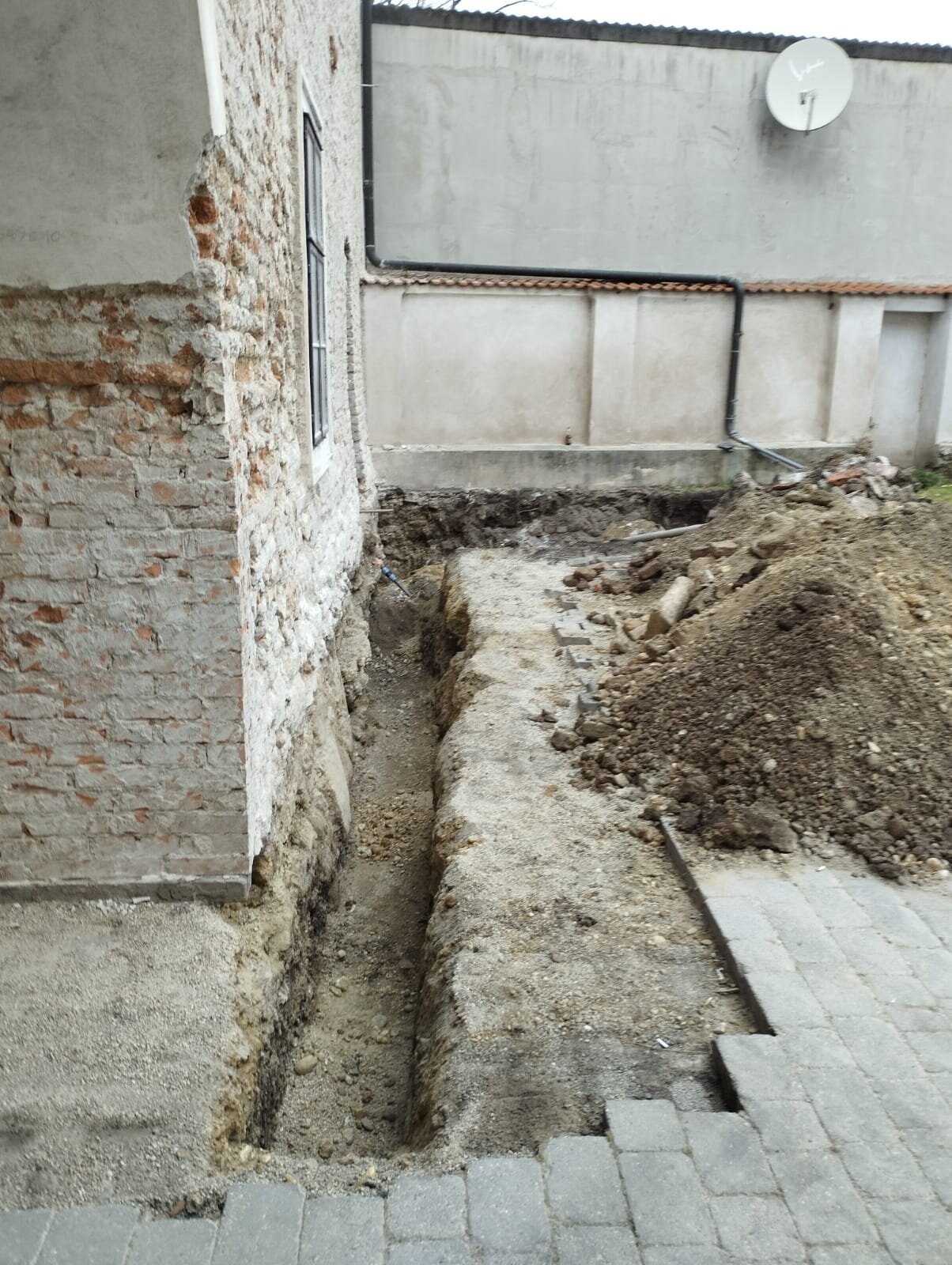 Minibagger zieht beim Garten begradigen im Bezirk Korneuburg eine wellige Rasenfläche auf ein einheitliches Niveau ab
