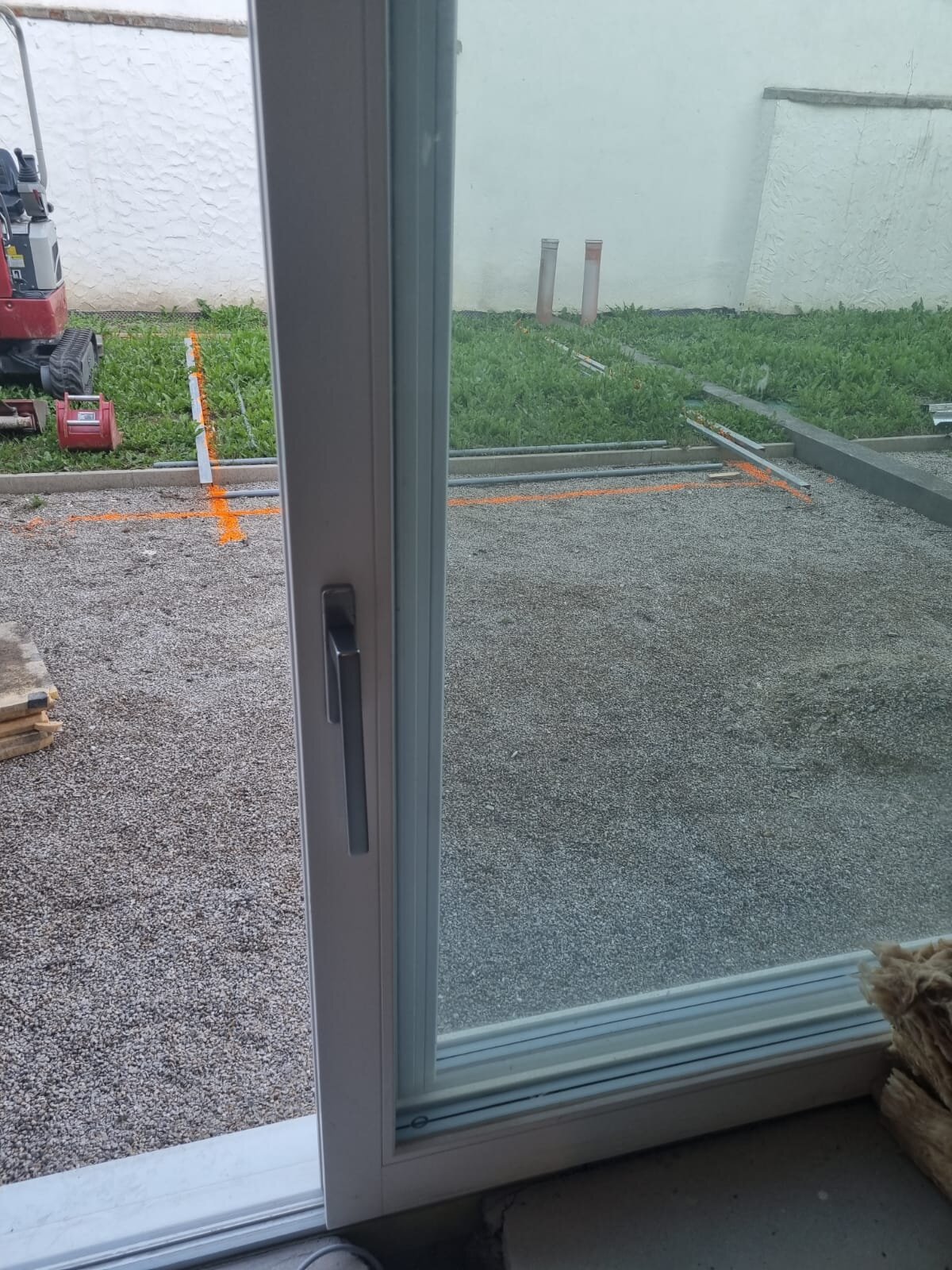 Minibagger beim Garten planieren im Bezirk Wiener Neustadt, der eine Fläche auf ein ebenes Planum abzieht