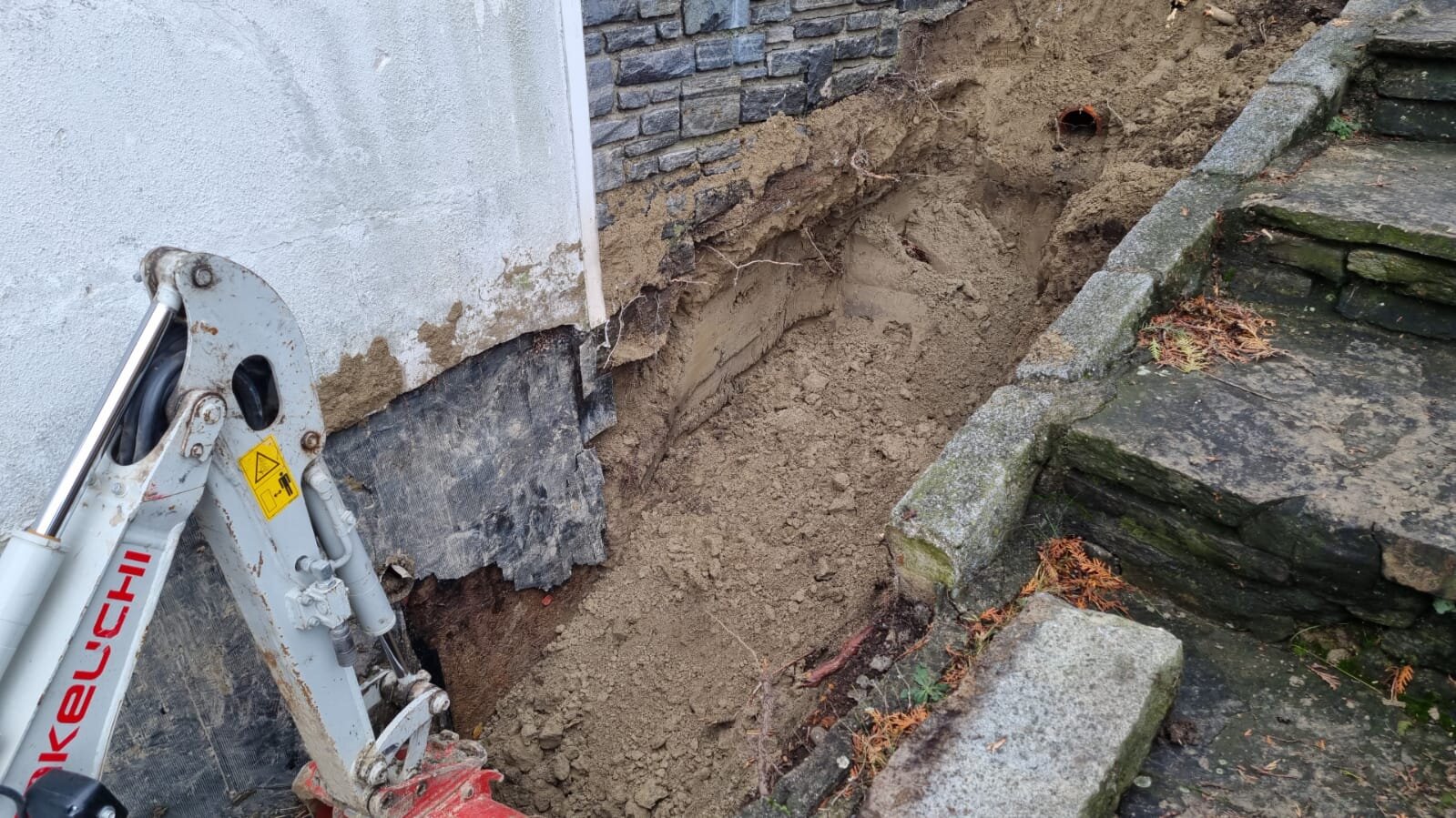 Bagger und Minibagger begradigen einen unebenen Garten im Bezirk Wiener Neustadt und ziehen die Rasenfläche auf ein Niveau ab