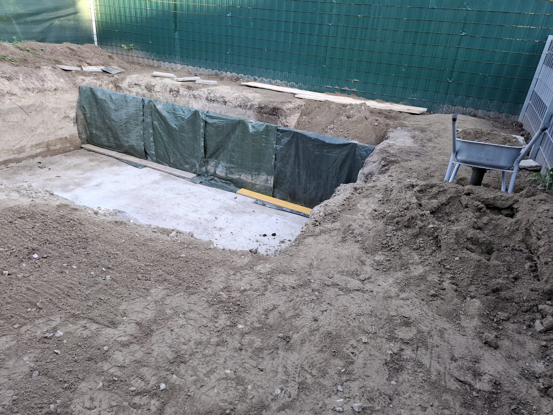 Minibagger modelliert Gelände in einem Garten im Bezirk Wiener Neustadt und formt sanfte Hügel und weiche Wellen bei der Geländemodellierung