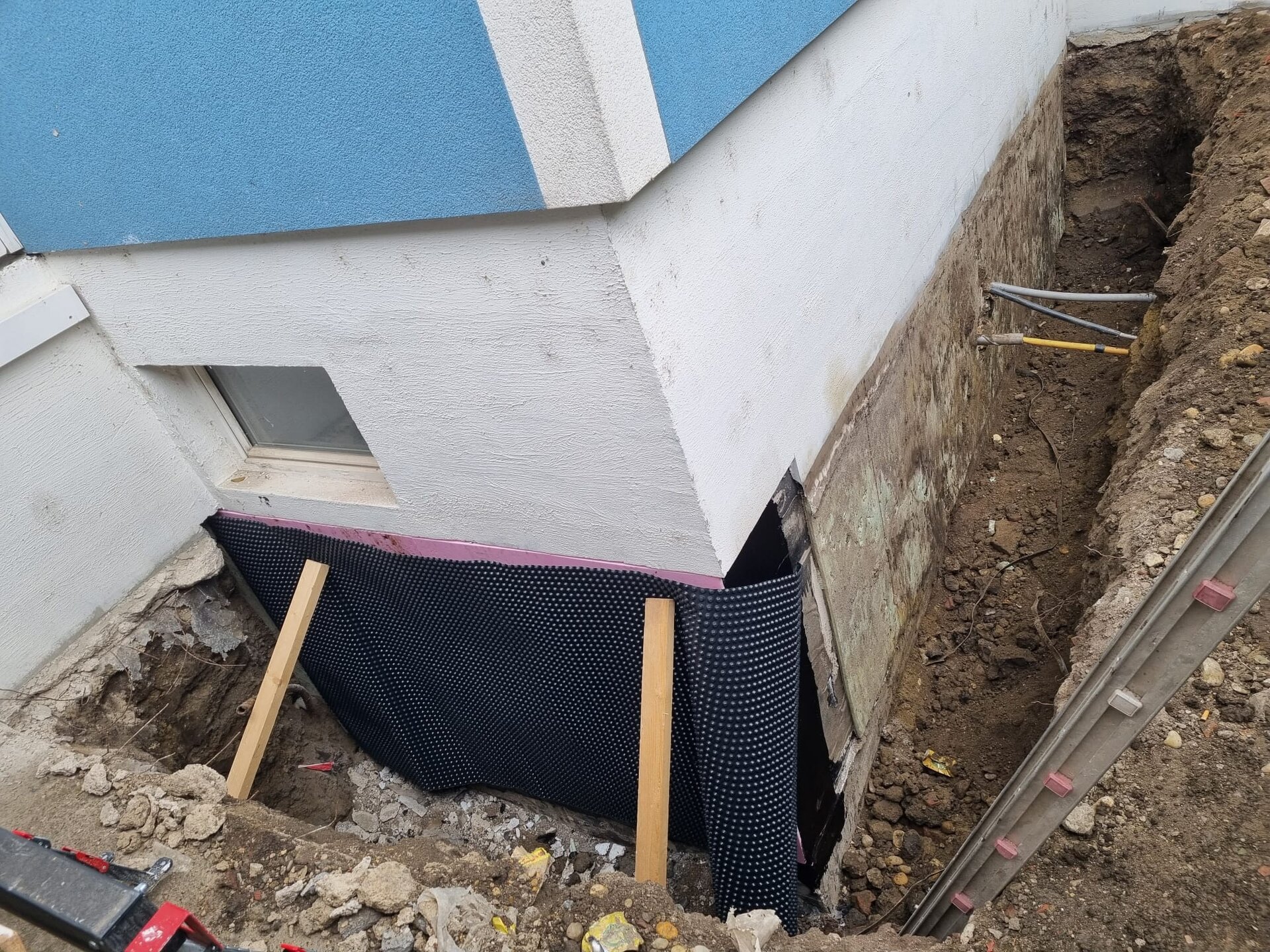 Minibagger gräbt im Bezirk Mödling Sträucher und Gestrüpp samt Wurzeln aus und rodet die verwilderte Fläche frei