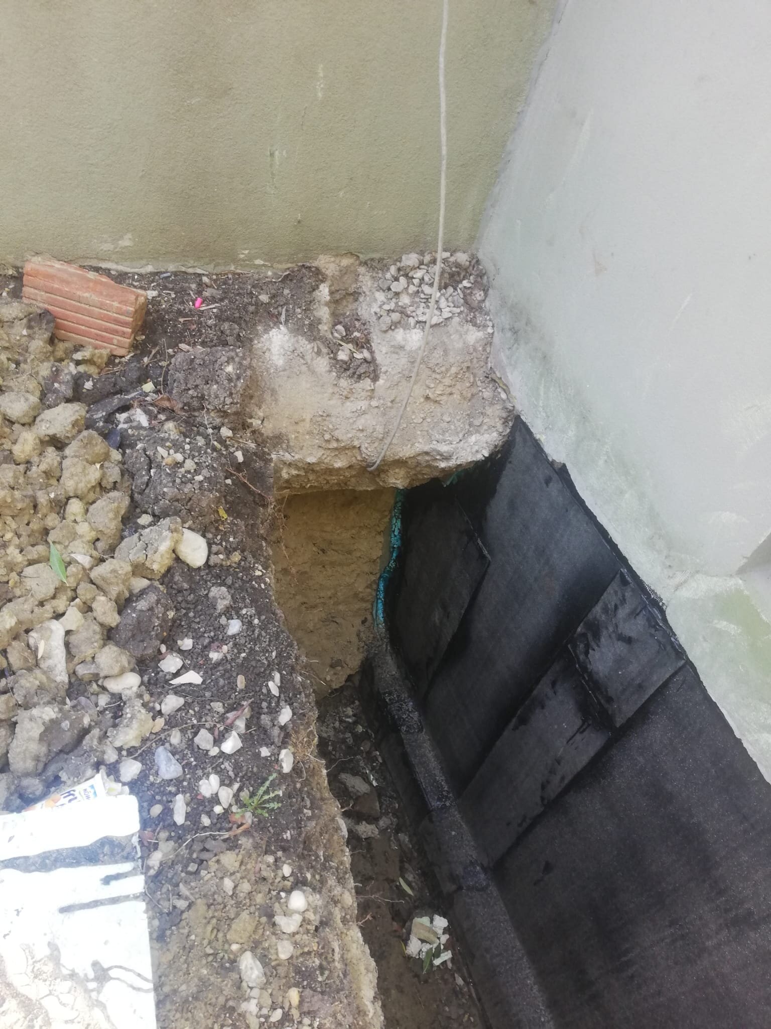 Minibagger zieht beim Garten planieren im Bezirk Mödling eine Fläche eben ab und stellt ein sauberes Planum her