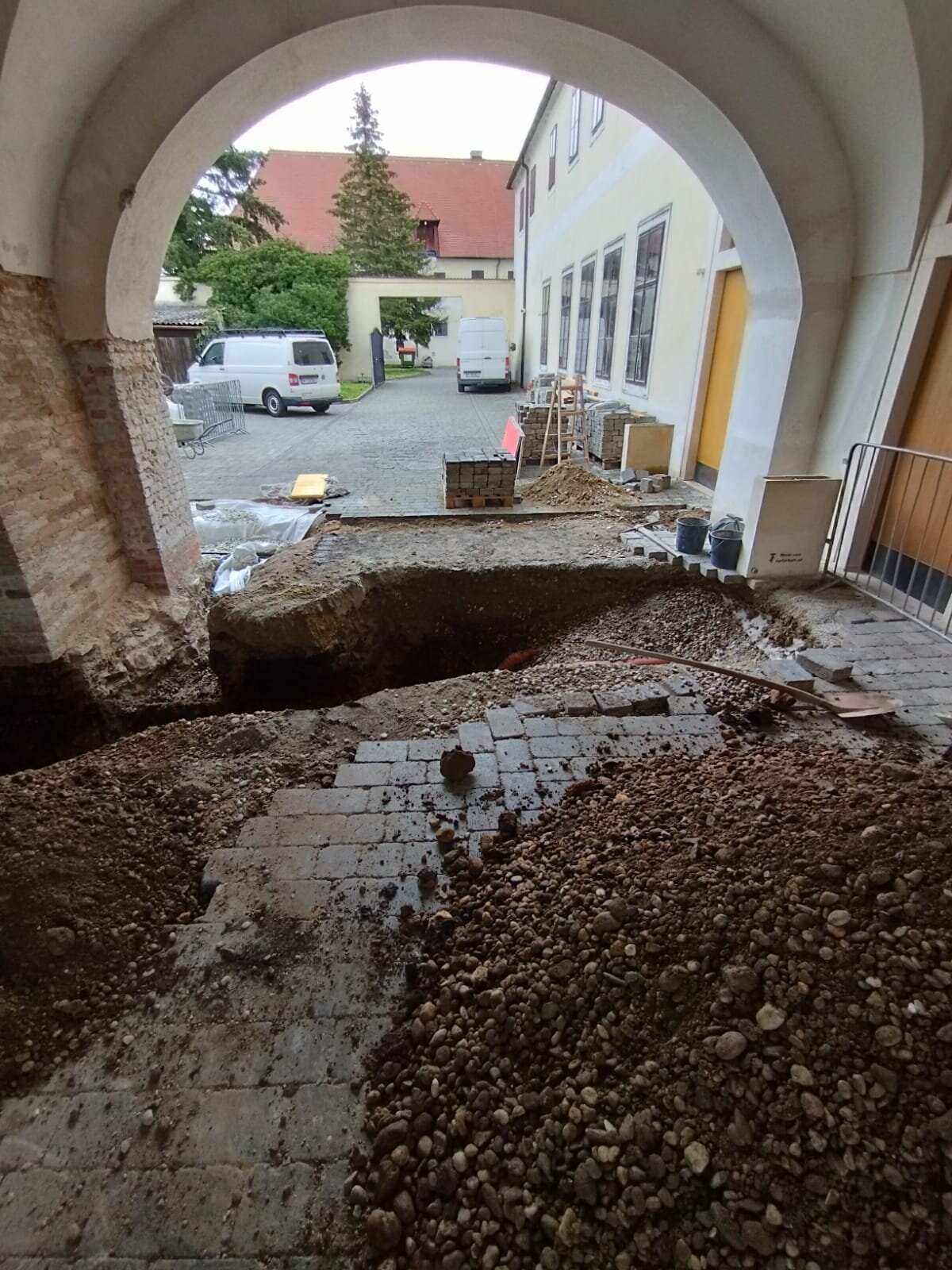 Minibagger schüttet einen Garten im Bezirk Wiener Neustadt auf und verteilt Material lagenweise zum Anheben des Niveaus