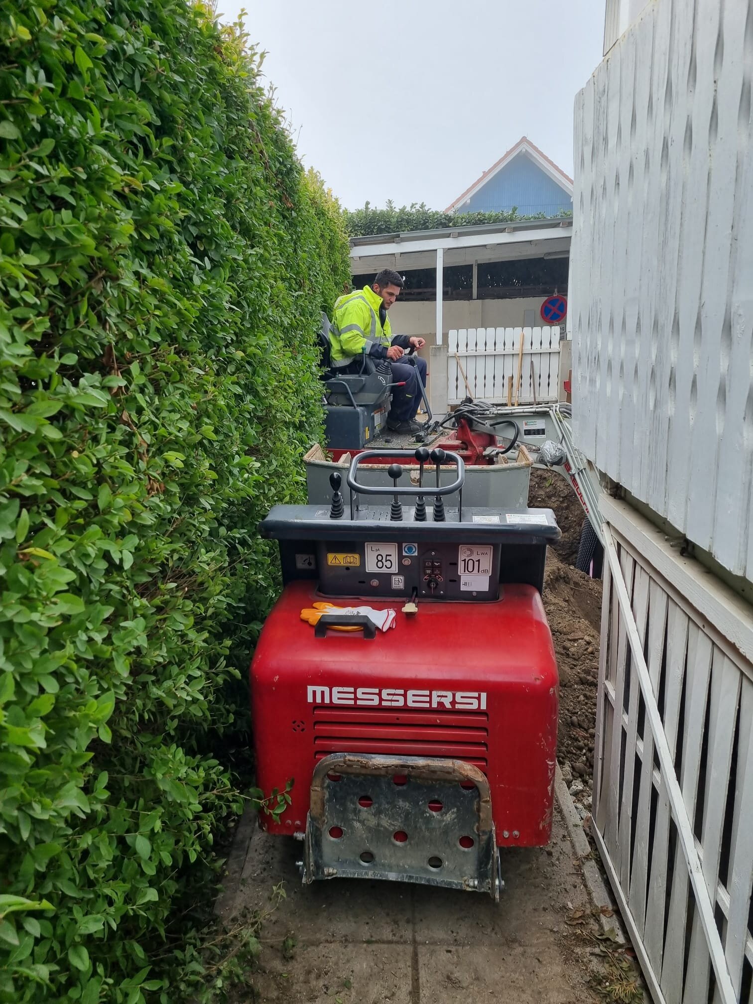 Minibagger hebt beim Hang terrassieren im Bezirk Mödling mehrere ebene Geländestufen aus einem steilen Hanggarten aus