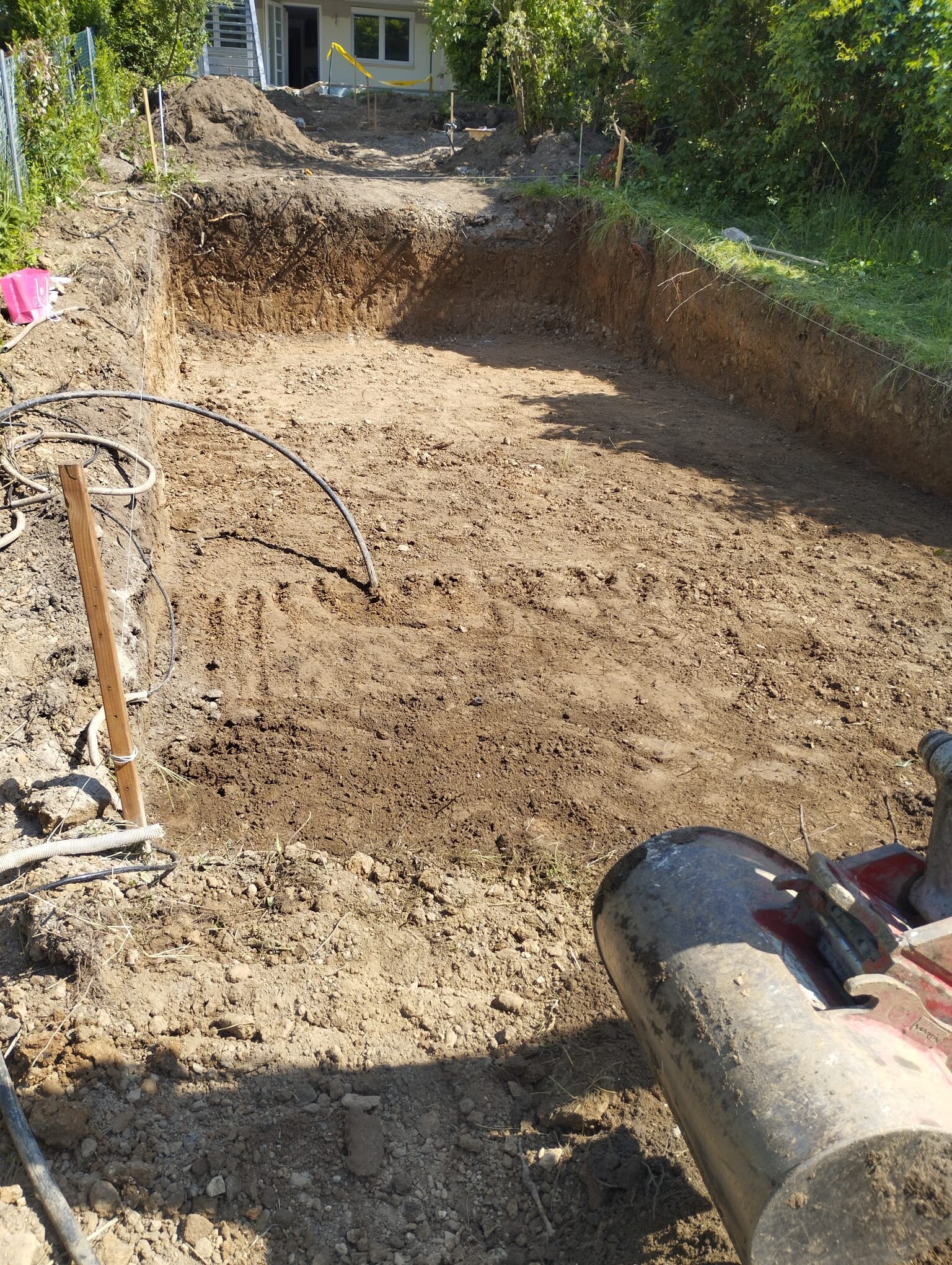 Minibagger formt eine Böschung beim Garten am Hang anlegen auf einem abschüssigen Grundstück im Bezirk Tulln