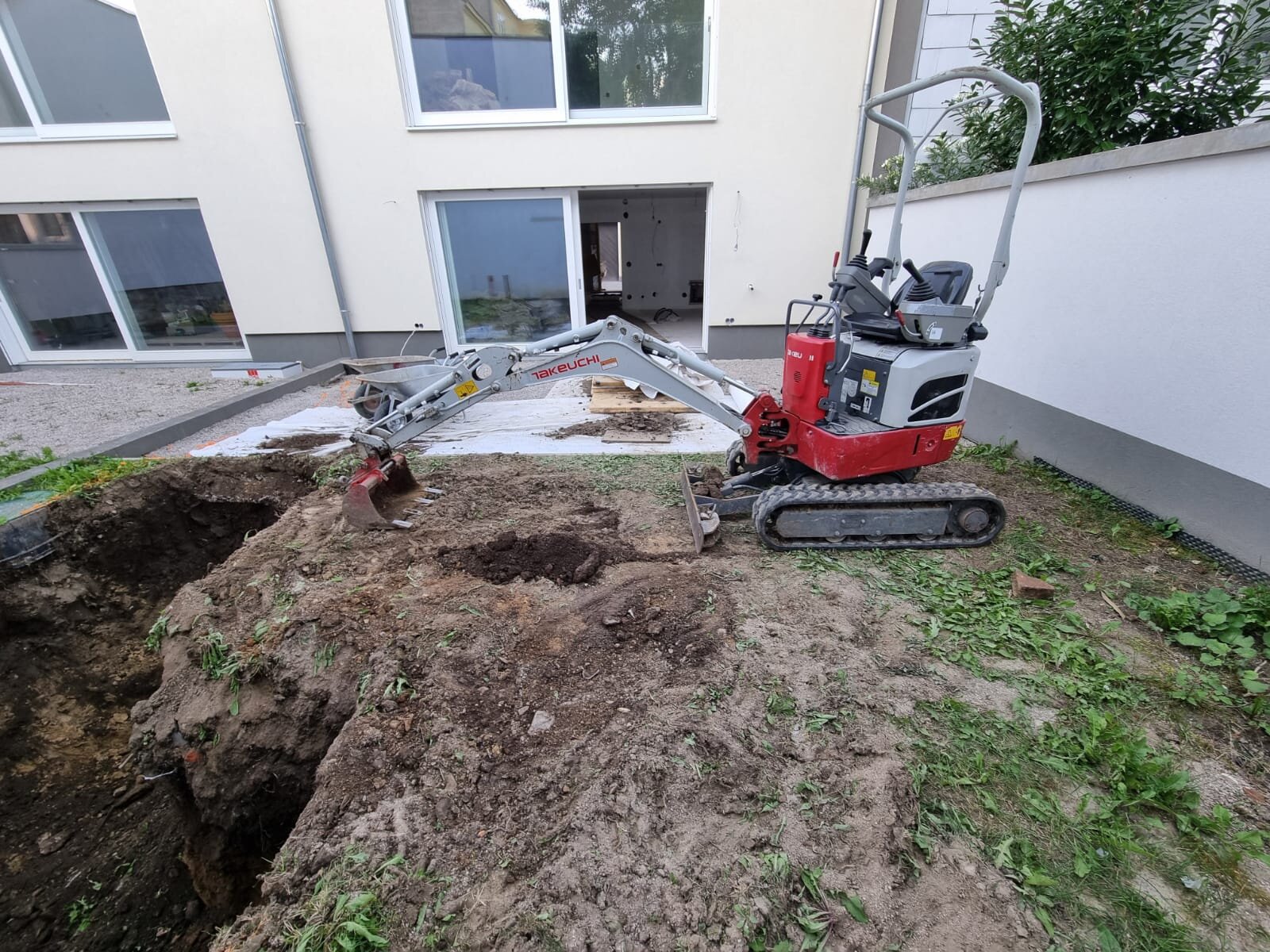 Minibagger beim Garten nivellieren im Bezirk St. Pölten, der Gartenboden wird mit dem Rotationslaser auf ein exaktes Niveau abgezogen